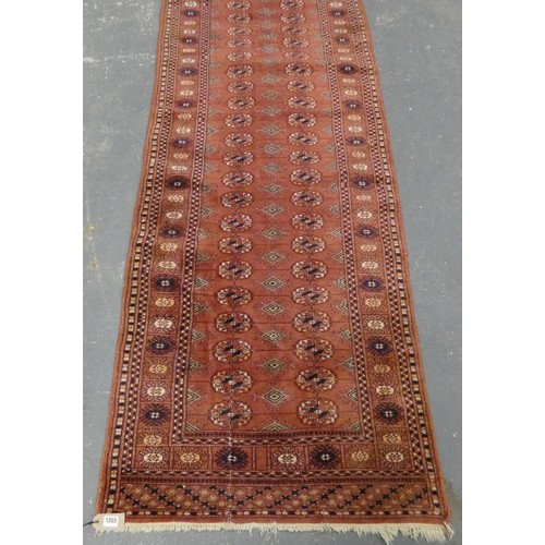 459 - Bokhara runner, with twenty six rows of two geometric motifs to the centre and border on red ground,... 