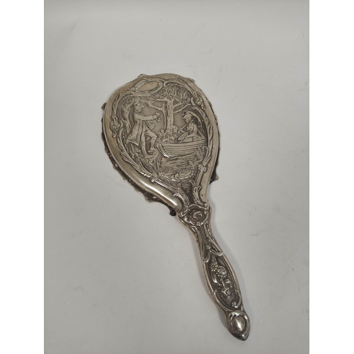 107 - Silver hand mirror, embossed with a couple in a landscape with trees, and matching hair brushes, by ... 