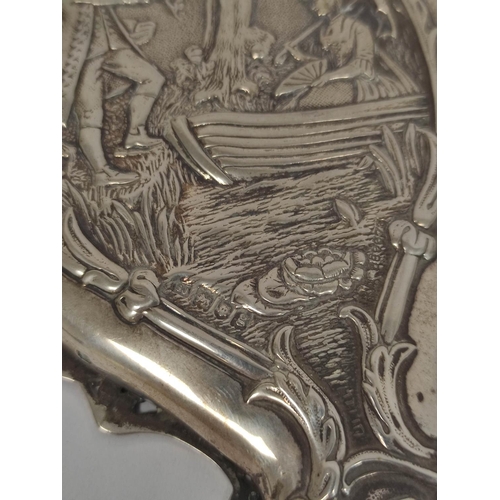 107 - Silver hand mirror, embossed with a couple in a landscape with trees, and matching hair brushes, by ... 