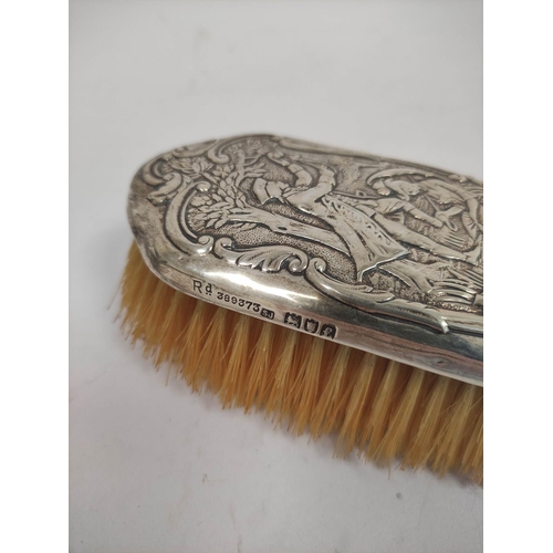 107 - Silver hand mirror, embossed with a couple in a landscape with trees, and matching hair brushes, by ... 