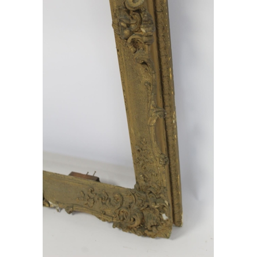 298 - 19th century gilt picture frame with floral and foliate scroll gesso moulding, the top surmounted by... 