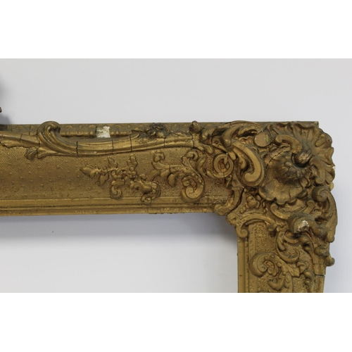 298 - 19th century gilt picture frame with floral and foliate scroll gesso moulding, the top surmounted by... 