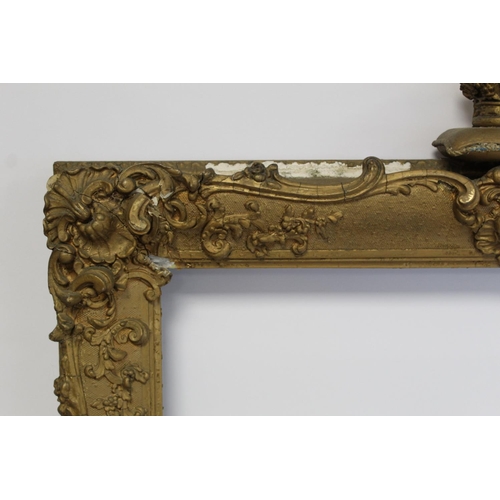 298 - 19th century gilt picture frame with floral and foliate scroll gesso moulding, the top surmounted by... 