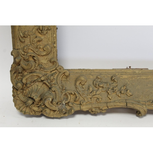 298 - 19th century gilt picture frame with floral and foliate scroll gesso moulding, the top surmounted by... 