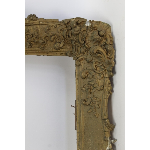 298 - 19th century gilt picture frame with floral and foliate scroll gesso moulding, the top surmounted by... 