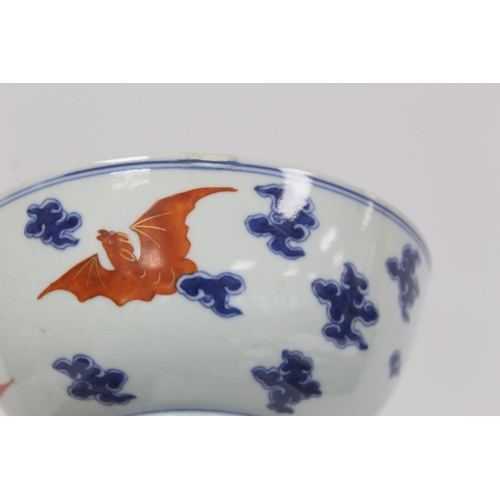 319 - 18th century Chinese porcelain circular bowl decorated with bats amongst clouds, in iron red, blue a... 