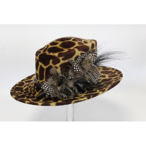 416 - Three Philip Treacy of London hats: faux leopard skin with feathers; dark plum straw with pink ribbo... 