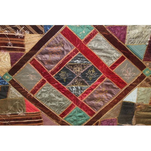 428 - A Victorian 'crazy' pattern patchwork quilt or panel with central diamond lozenge, in polychrome cot... 