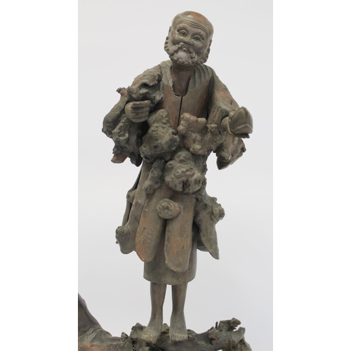 338 - 19th or early 20th century Oriental carved root wood figure of a peddler holding a shoe, the face wi... 