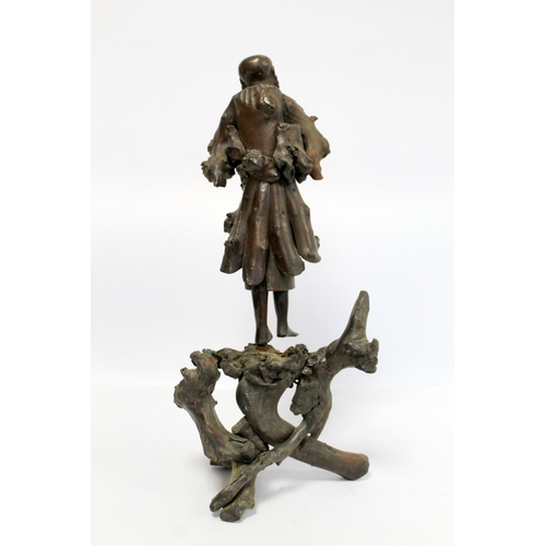 338 - 19th or early 20th century Oriental carved root wood figure of a peddler holding a shoe, the face wi... 