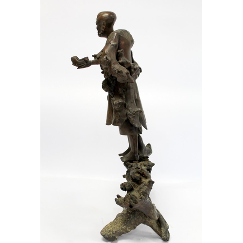 338 - 19th or early 20th century Oriental carved root wood figure of a peddler holding a shoe, the face wi... 