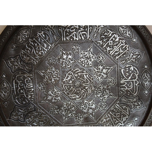 340 - Large antique Persian circular copper charger inlaid with white metal, the central octagonal flowerh... 