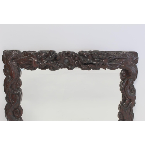 342 - Late 19th or early 20th century Chinese carved hardwood wall mirror, the frame in the form of two sc... 