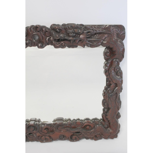 342 - Late 19th or early 20th century Chinese carved hardwood wall mirror, the frame in the form of two sc... 