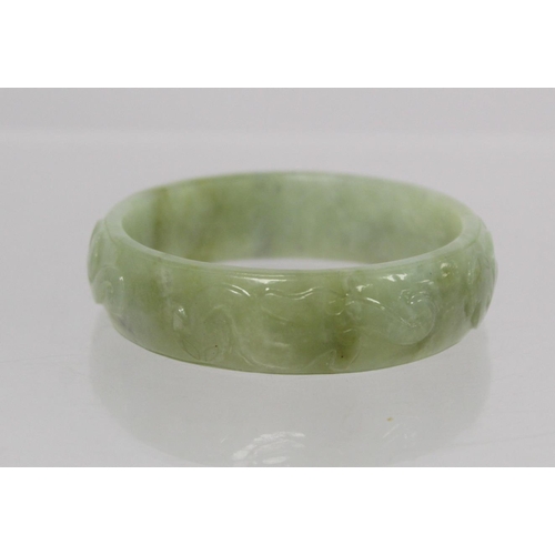 368 - Chinese pale green mottled jade bangle with relief carved decoration of Chilong, approx. 7.5cm diam.... 