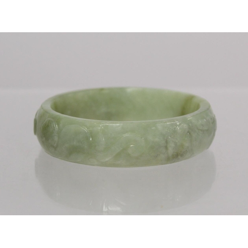 368 - Chinese pale green mottled jade bangle with relief carved decoration of Chilong, approx. 7.5cm diam.... 