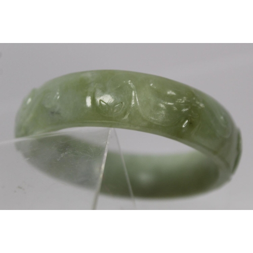 368 - Chinese pale green mottled jade bangle with relief carved decoration of Chilong, approx. 7.5cm diam.... 