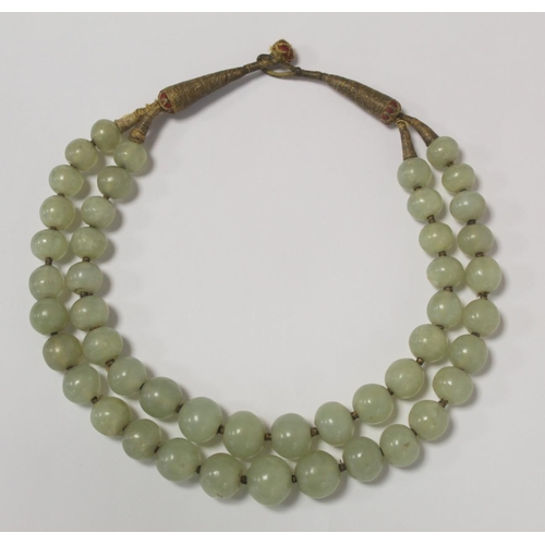 381 - Antique Oriental double strand of jade beads, probably Chinese, with loop and button fastening in me... 