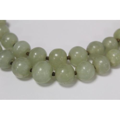 381 - Antique Oriental double strand of jade beads, probably Chinese, with loop and button fastening in me... 