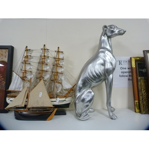 122 - Composite model of a seated greyhound and two model boats.