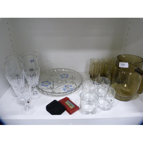 135 - Smokey glass lemonade set, other glassware etc (one shelf).