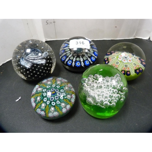 316 - Five assorted glass paperweights to include Caithness and others.