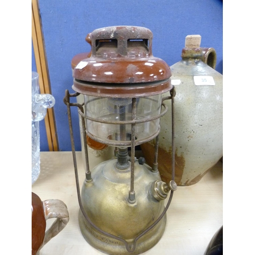 35 - Stoneware pig water bottle, studio pottery flagon with stopper, pottery crock and an oil lamp. ... 