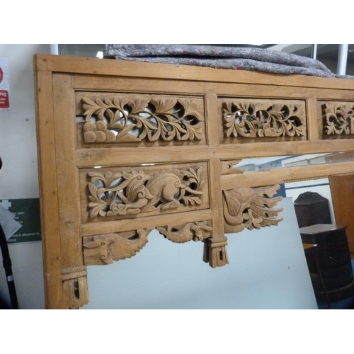 479 - Large Indonesian style wood-framed mirror with carved top.