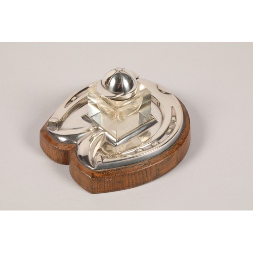 157a - Electro plated silver ink stand,in the form of a horseshoe, mounted to an oak base, glass inkwell wi... 