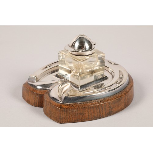 157a - Electro plated silver ink stand,in the form of a horseshoe, mounted to an oak base, glass inkwell wi... 