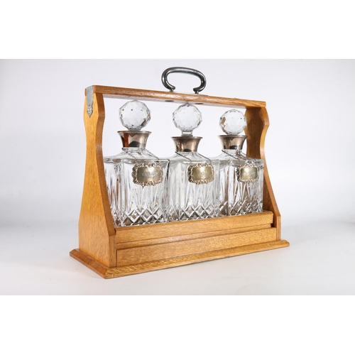 136 - Oak and sterling silver mounted three decanter Tantalus, fitted with three cut glass silver mounted ... 