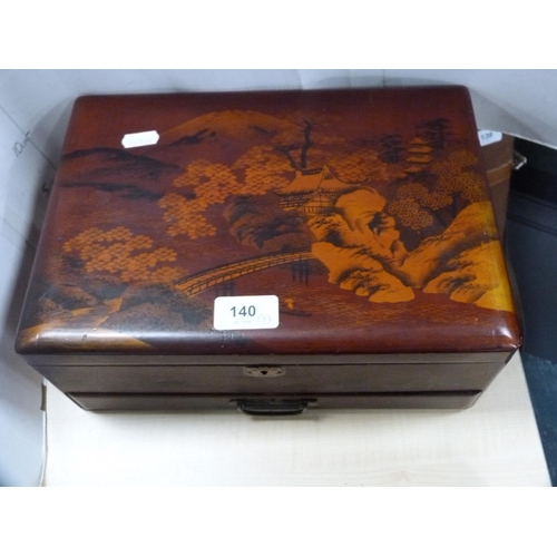 140 - Japanese lacquered sewing box, similar lacquered glove box and a musical jewellery box.  (3)