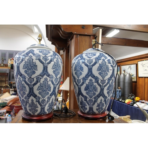 629 - Pair of large blue and white floral decorated table lamps, on hardwood stand, 54cm high.