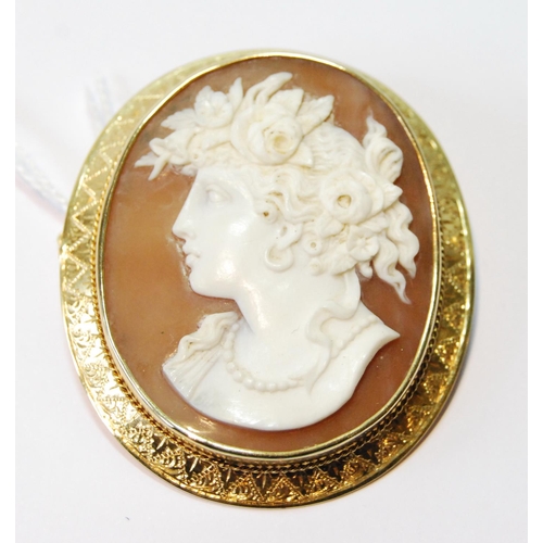 58 - Victorian oval cameo brooch with female portrait in gold engraved mount, probably 15ct, 56mm x 48mm.