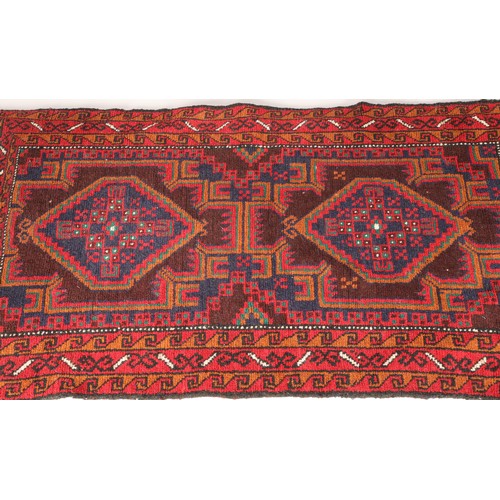 469 - Persian belouchi rug, red ground dark blue border with geometric pattern in brown, blue and green, w... 