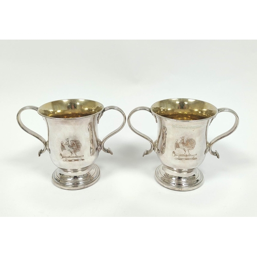 19 - Pair of early Sheffield plated two-handled cups with loop handles, crested, on inset mahogany bases,... 