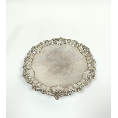 22 - Silver circular waiter with unusually cut scroll and bead border, initialled beneath, on pad feet, b... 