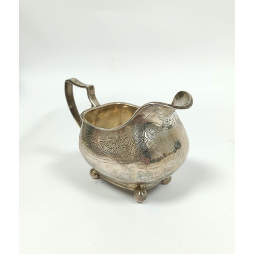 23 - Silver cream jug of boat shape with engraved and pin struck decoration, on ball feet by Charles &... 