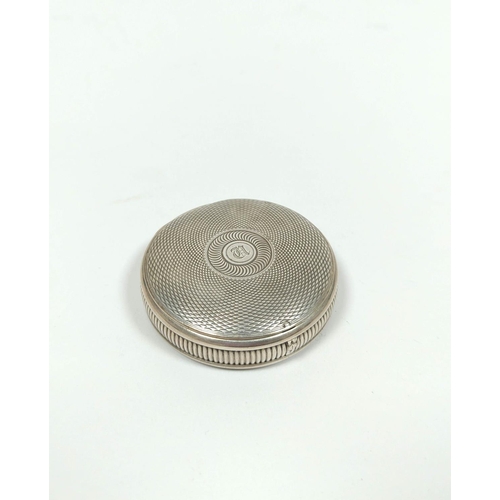 26 - Silver circular snuff box of watch case style, engine turned all over with gold joint and gilt inter... 