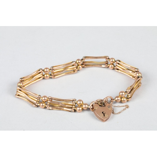 61 - 9 carat yellow gold gate link bracelet; with heart shaped padlock clasp; 10g