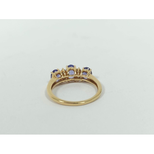 133 - Diamond and tanzanite three stone ring,. in gold, probably 18ct, size 'K½'. 