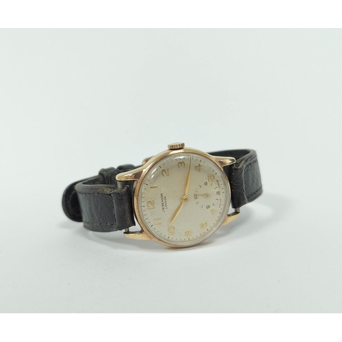 135 - Gent's 9ct gold watch for Benson, with silvered and gold dial, 1955, 31mm on strap.