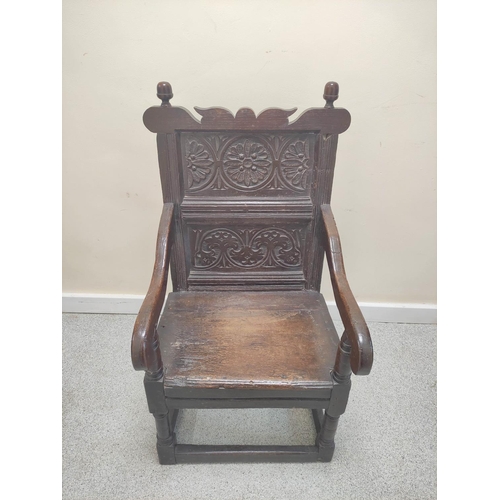 399 - 17th century wainscot chair, the foliate carved panel back with acorn finials, above solid seat, sha... 