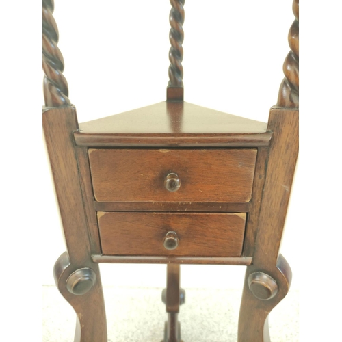 411 - Mahogany wig stand, the saucer top above open recess and two small drawers, on platform base with tr... 