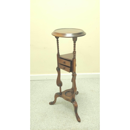 411 - Mahogany wig stand, the saucer top above open recess and two small drawers, on platform base with tr... 