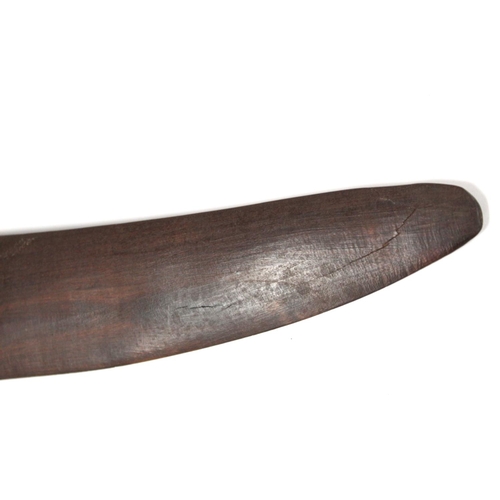 354 - Antique hardwood boomerang of plain curved form, 65cm long, some damages.