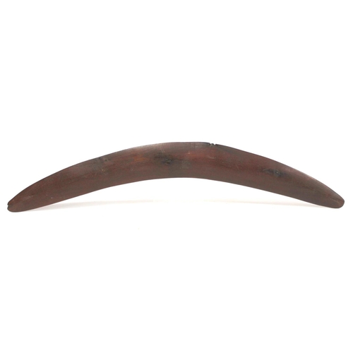 354 - Antique hardwood boomerang of plain curved form, 65cm long, some damages.