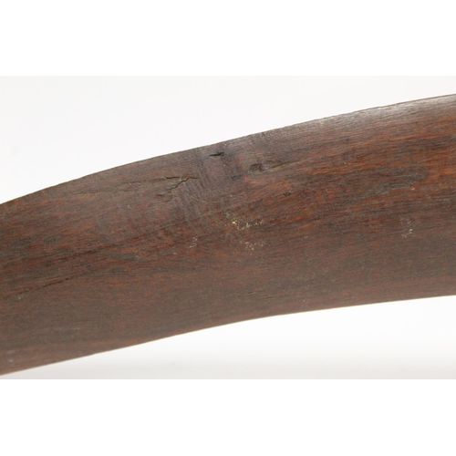 354 - Antique hardwood boomerang of plain curved form, 65cm long, some damages.