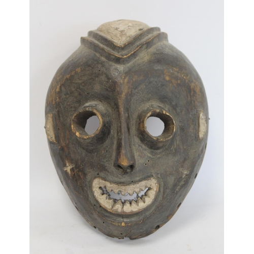 357 - African tribal mask of ovoid form with cylindrical eyes, mouth with jagged teeth and stylised hair, ... 