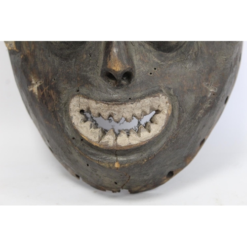 357 - African tribal mask of ovoid form with cylindrical eyes, mouth with jagged teeth and stylised hair, ... 